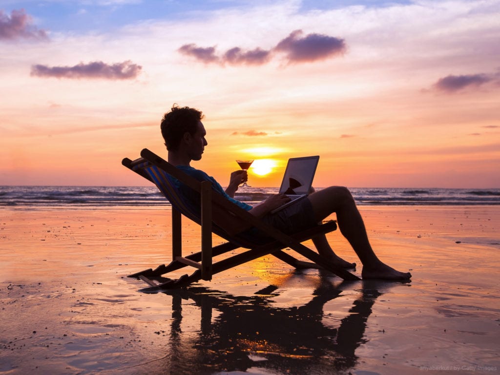 trabalho intermitente trabalho intermitente - homem na praia setando numa espreguiçadeira no fim de tarde tomando vinho e lendo