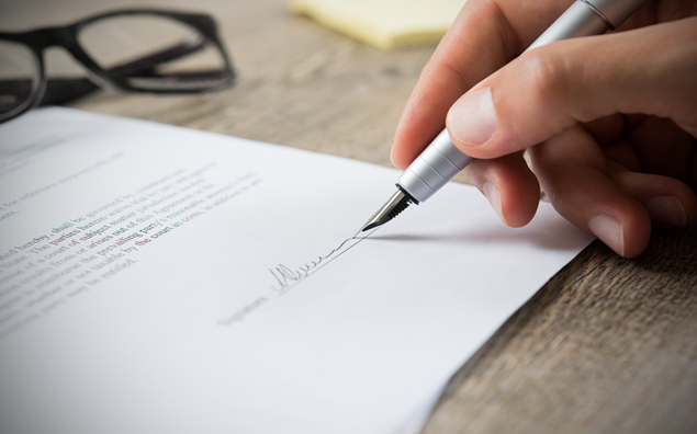 Trabalho intermitente e a reforma trabalhista - mão masculina que assina o contrato do empregado